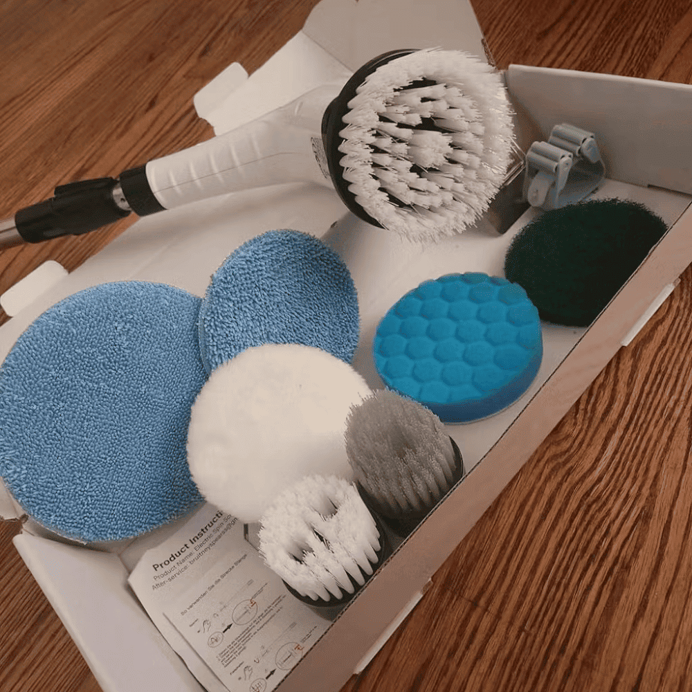 Set of car cleaning tools including sponges and brushes in a box on a wooden floor.