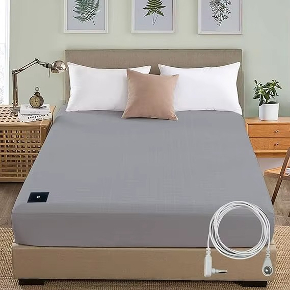 Gray mattress cover with heating element on a bed in a bedroom setting